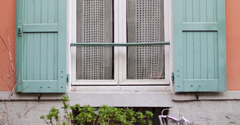 Rustic Charm - Window with green shutters on peach colored house in Paris